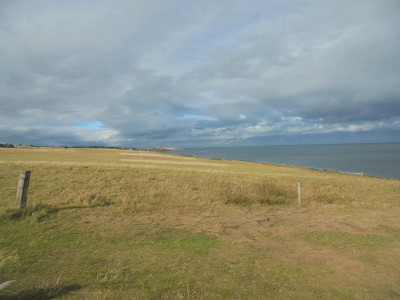 craster about 1 mile away with Dunstanburgh Castle in the distance