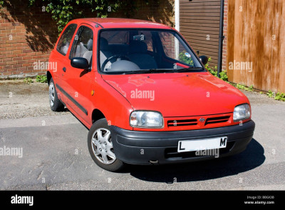 a-red-nissan-micra-parked-beside-the-road-BBGX3B.jpg