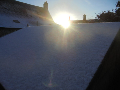 sun on a snowy shed roof